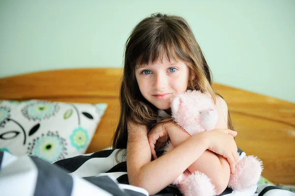 Portret van ontwaken meisje zitten in bed — Stockfoto