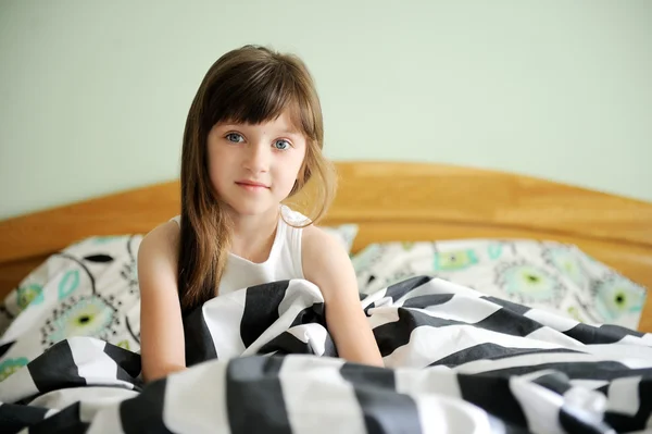 Retrato de menina acordada sentada na cama — Fotografia de Stock