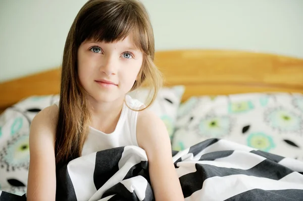 Portret obudzić dziewczynka siedzi na łóżku — Zdjęcie stockowe