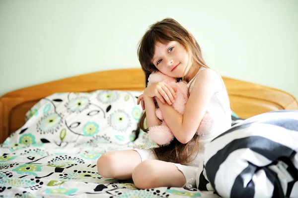 Retrato de niña despierta sentada en la cama — Foto de Stock