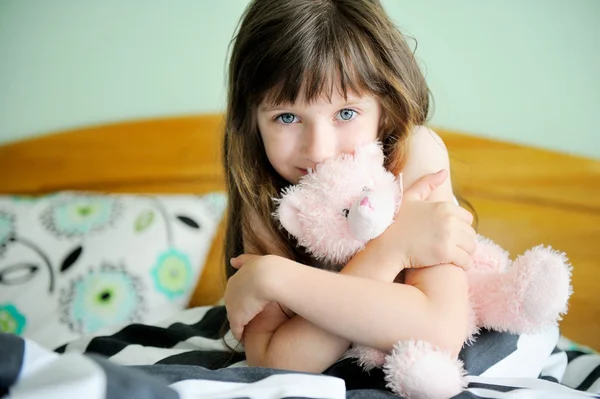 Porträt eines kleinen Mädchens, das im Bett sitzt — Stockfoto