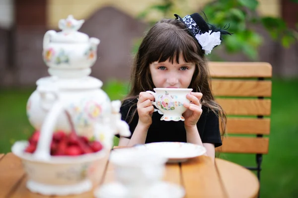 Elegante niña teniendo una fiesta de té al aire libre — Foto de Stock