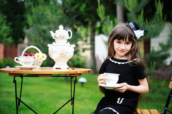 Elegant barn tjej som har en tebjudning utomhus — Stockfoto
