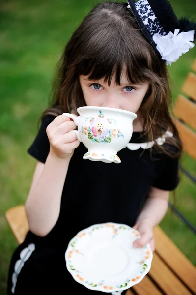 Elegante kind meisje hebben een thee partij in de buitenlucht — Stockfoto