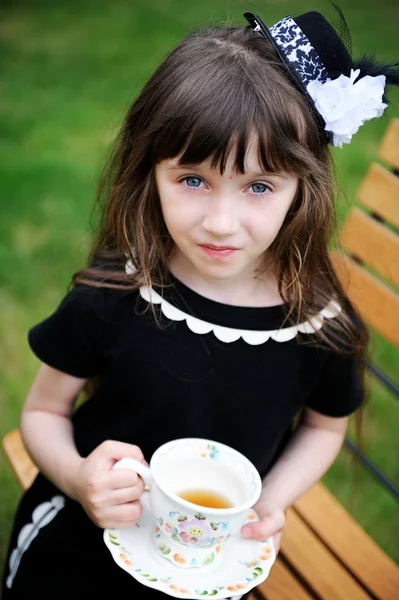 Elegante kind meisje hebben een thee partij in de buitenlucht — Stockfoto