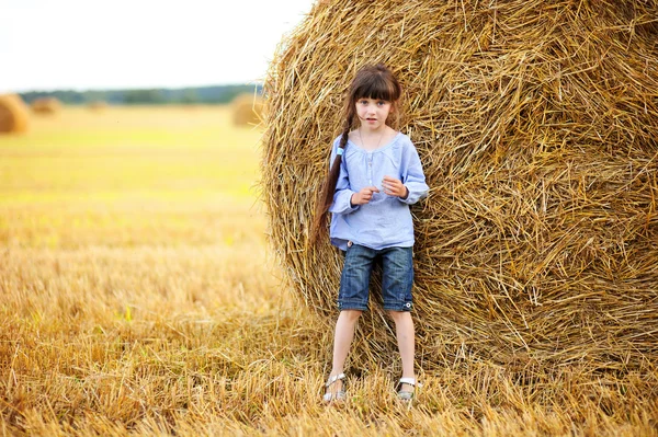 Little girl and big haystack — Stock Photo, Image