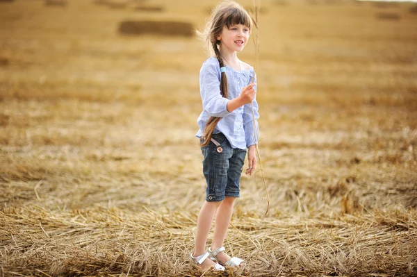 Маленька дівчинка тримає шпильку пшениці — стокове фото