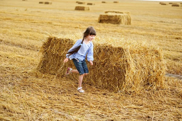 Little girl running around on a field — Stock Photo, Image