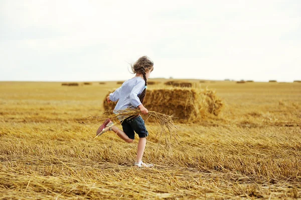 Little girl running around on a field — Stock Photo, Image