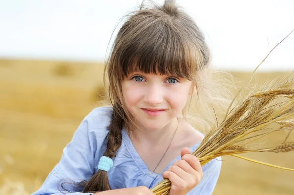 Little girl holding bunch of wheat ears — Stock Photo, Image