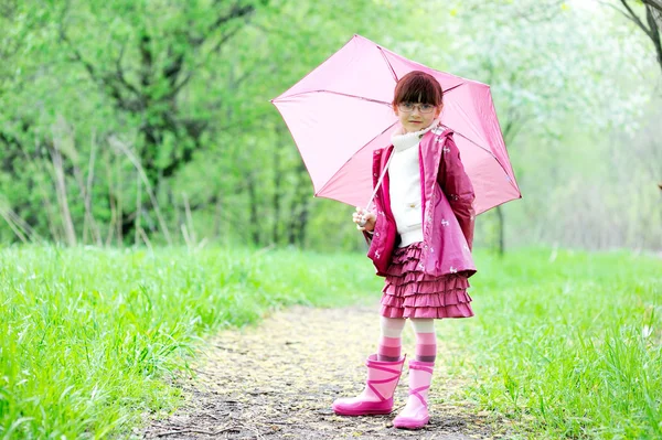 Kid girl posing outdoors with pink umbrella — Stock Photo, Image