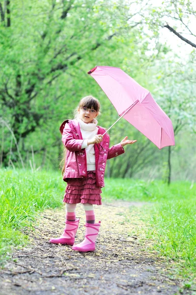 Mädchen posiert im Freien mit rosa Regenschirm — Stockfoto