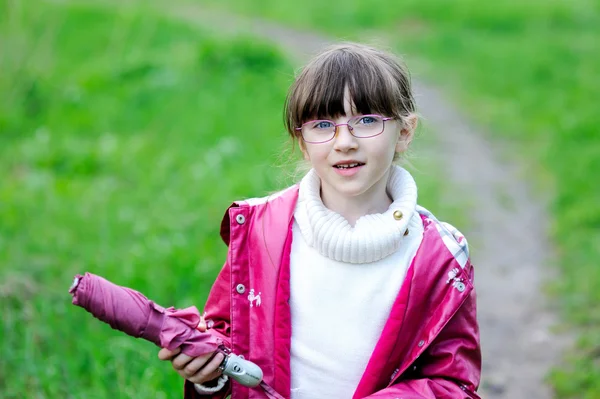 Porträt eines kleinen Mädchens posiert mit rosa Regenschirm — Stockfoto