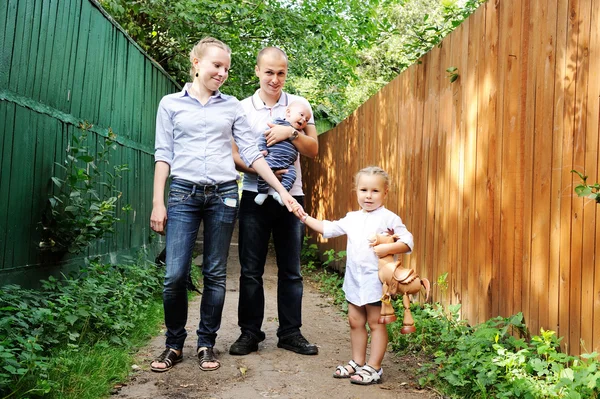 Gelukkige ouders met kinderen poseren buitenshuis — Stockfoto