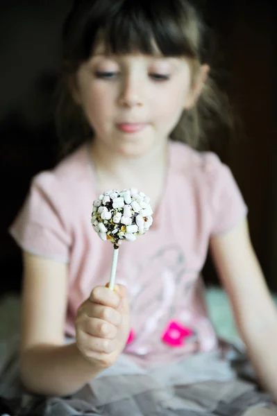 Lustiges Kindermädchen zeigt einen Marshmallow-Kuchen — Stockfoto