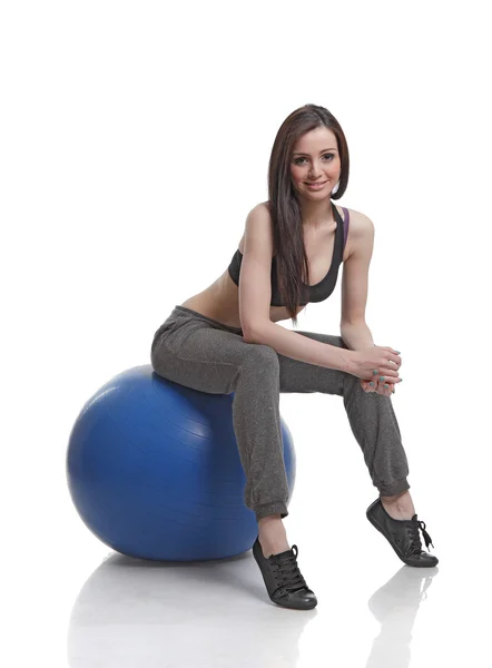 Athlète féminine assise sur une balle de fitness — Photo