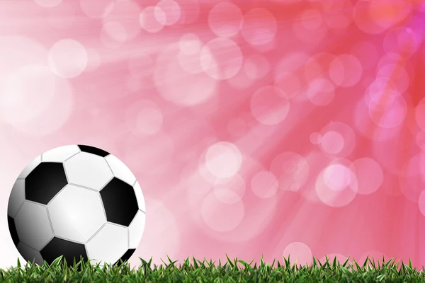 Футбол в зеленой траве с цветным фоном — стоковое фото