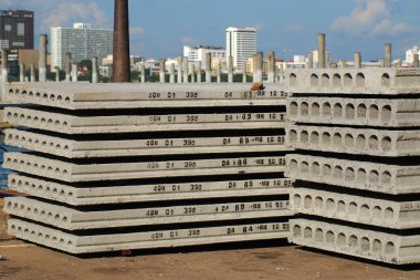 Pallets of new concrete blocks under sunlight against blue sky clipart