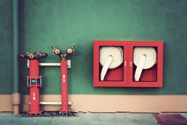 Oldtimer-Hydrant mit Wasserschläuchen und Feuerlöschgeräten — Stockfoto