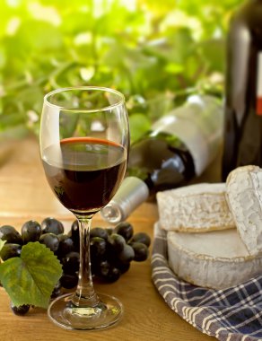 Red wine, Brie, Camembert and grape on the table clipart