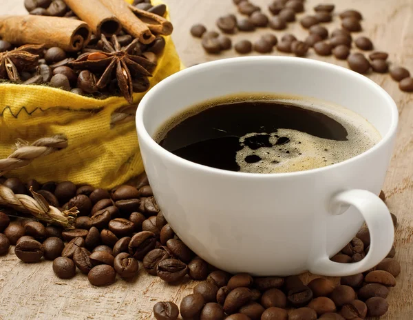 Koffiekopje op bonen met kaneelstokjes en anijs — Stockfoto