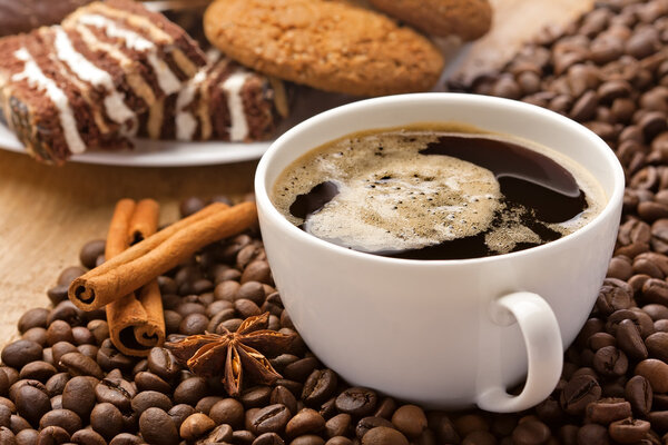 Coffee cup, sweets, cinnamon, anise on coffee beans