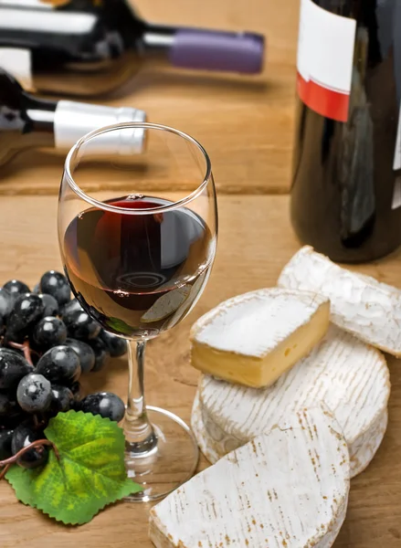 Vinho tinto, Brie, Camembert e uva na mesa — Fotografia de Stock