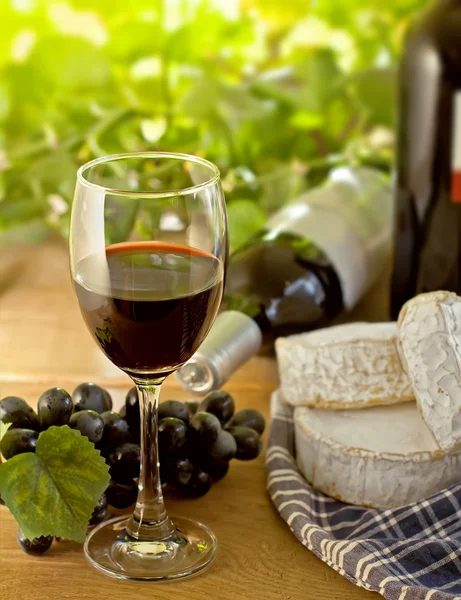 Красное вино, Бри, Камамбер и виноград на столе — стоковое фото