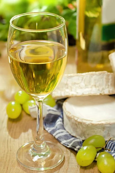 Weißwein, Brie, Camembert und Trauben auf dem Tisch — Stockfoto