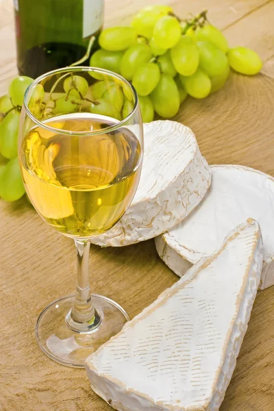 Białe wino, brie, camembert i winogron na stole — Zdjęcie stockowe
