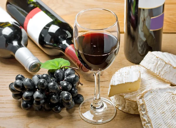 Rode wijn, brie, camembert en druivenmost op tafel — Stockfoto