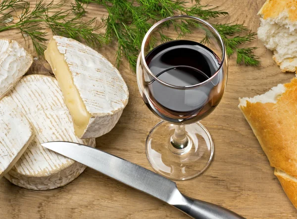 Czerwone wino, brie, camembert serów z chlebem na stole — Zdjęcie stockowe