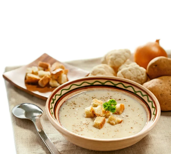 Суп и ингредиенты на скатерти — стоковое фото