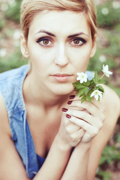 Beautiful girl in hat with white spring flowers — Stock Photo, Image