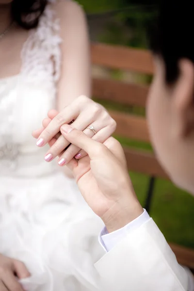 Noivo colocando um anel de casamento no dedo da noiva — Fotografia de Stock