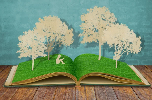 Papierschnitt von Kindern liest ein Buch unter Baum auf altem Buch — Stockfoto