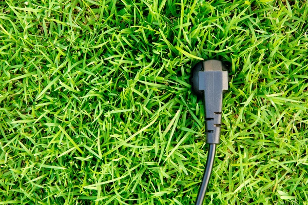 Energy concept outlet in fresh spring green grass — Stock Photo, Image