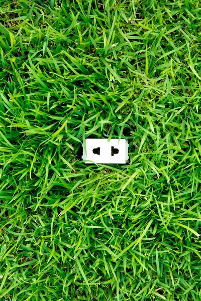 Green energy concept : outlet in grass — Stock Photo, Image
