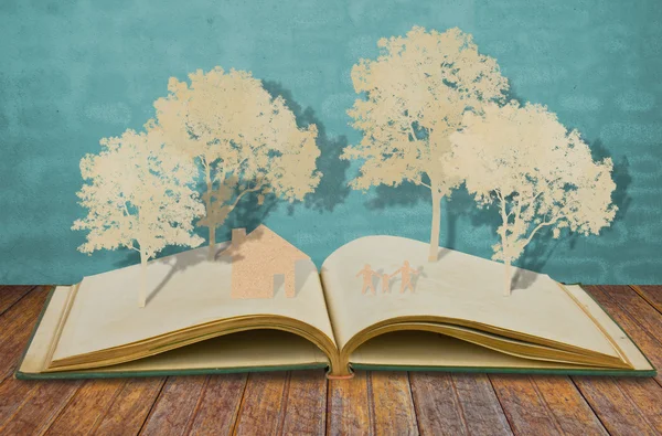 Papierschnitt des Familiensymbols auf altem Buch (Haus, Baum, Mama, Papa, Chi) — Stockfoto