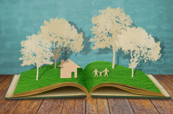 Papier gesneden van familie symbool op oude gras boek (huis, boom, moeder, d — Stockfoto