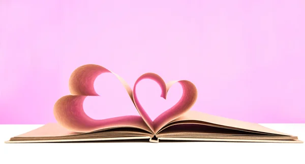 白の背景に隠れてに分離された心臓の形の開いたページが付いている本 — ストック写真