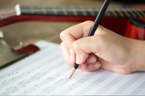 Ręka z blachy ołówek i muzyka — Zdjęcie stockowe