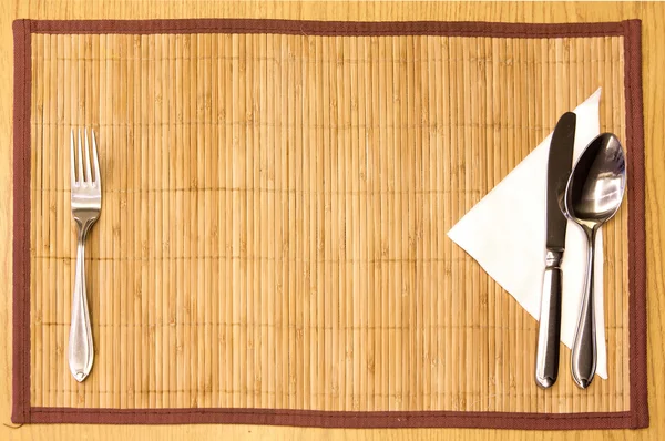 Tablo randevular-çatal, bıçak, kaşık, ipek bambu hasır peçeteye — Stok fotoğraf