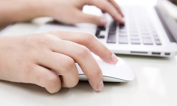 Primer plano de la mujer de negocios escribiendo a mano en el teclado del ordenador portátil con mo Imagen de stock