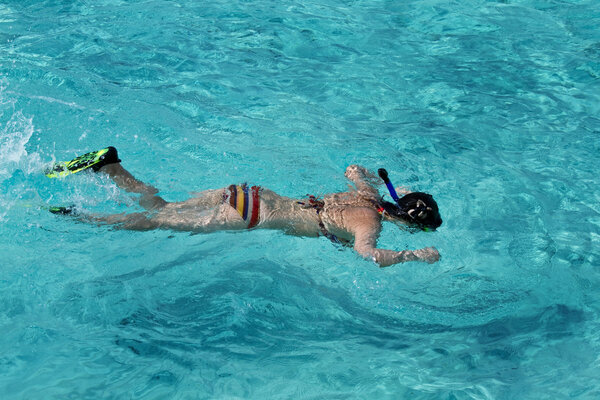 Beautiful asian girl snorkeling in crystal clear Maldive waters