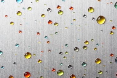 Colorful water drops on metal surface clipart