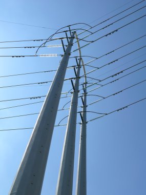 Power poles against blue sky clipart