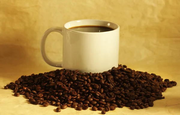 杯热咖啡的咖啡豆堆上 — 图库照片