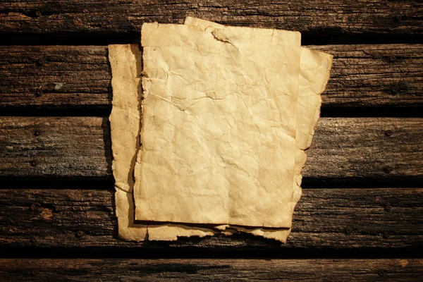 Old paper on wooden wall — Stock Photo, Image