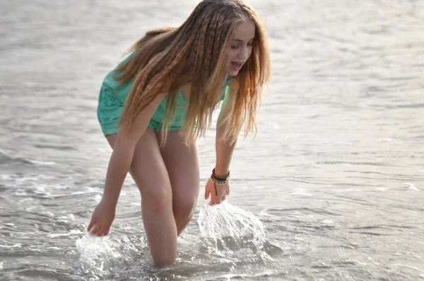 Gelukkig jongedame uitgevoerd op strand — Stockfoto